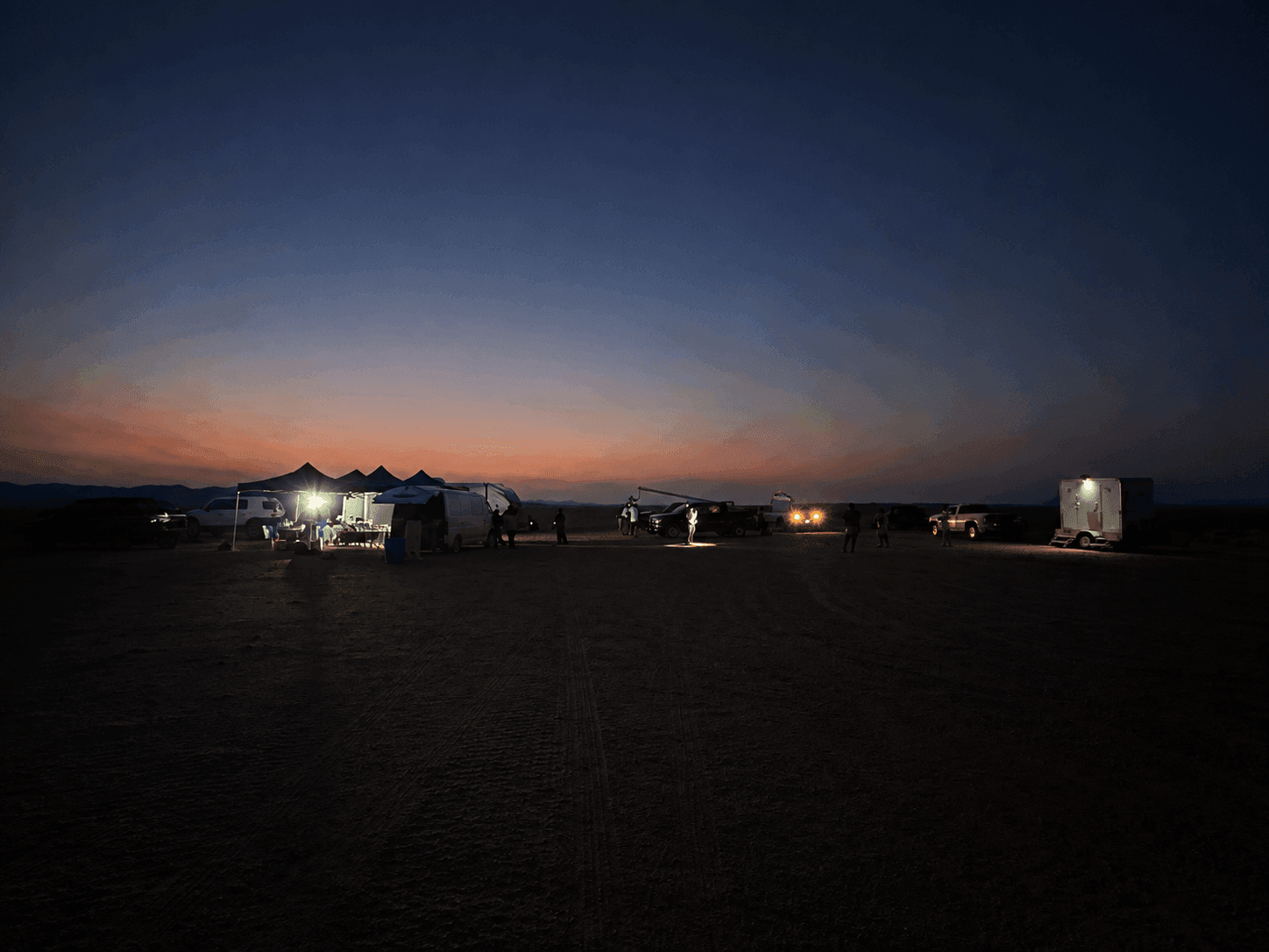 Behind-the-scenes desert production basecamp at twilight