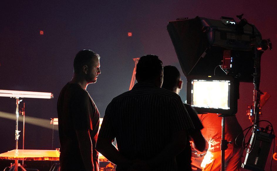 Filmmaker operating a cinema camera on a warmly lit Toosuns production set.
