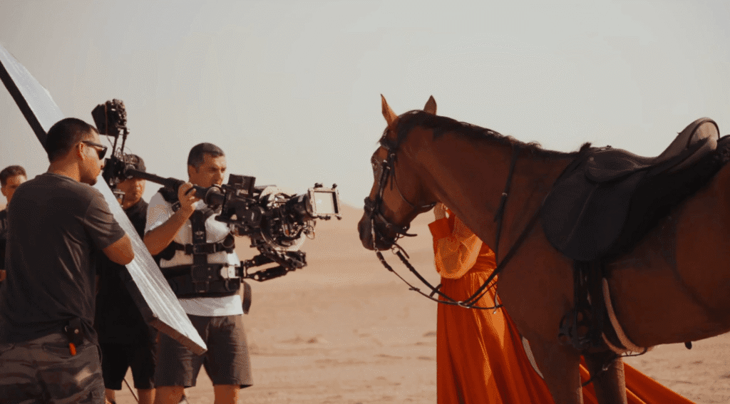 Toosuns film crew capturing a desert campaign scene with a horse and model.