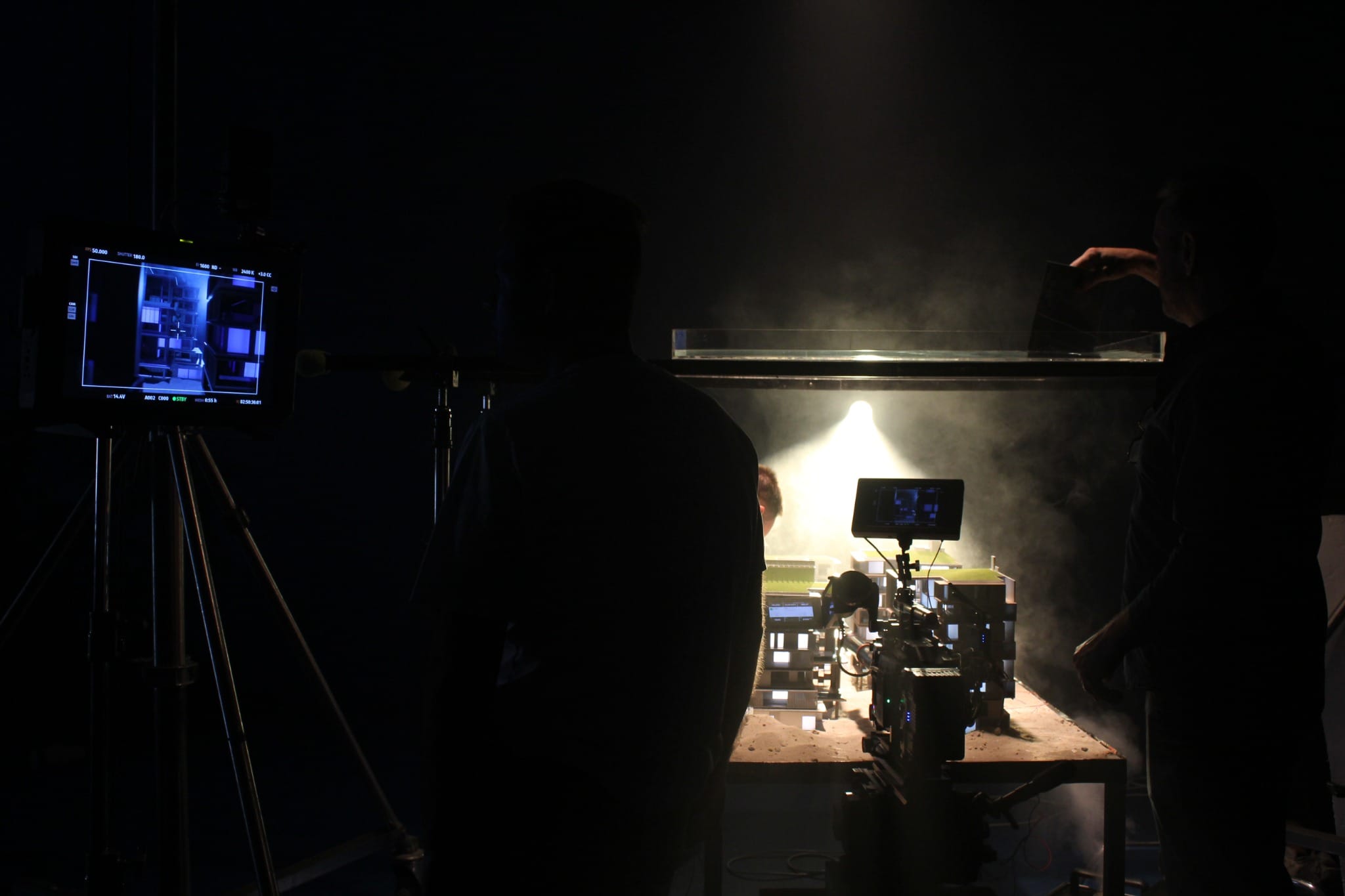 Camera and lighting setup filming the illuminated Six Senses residence miniature in a studio.