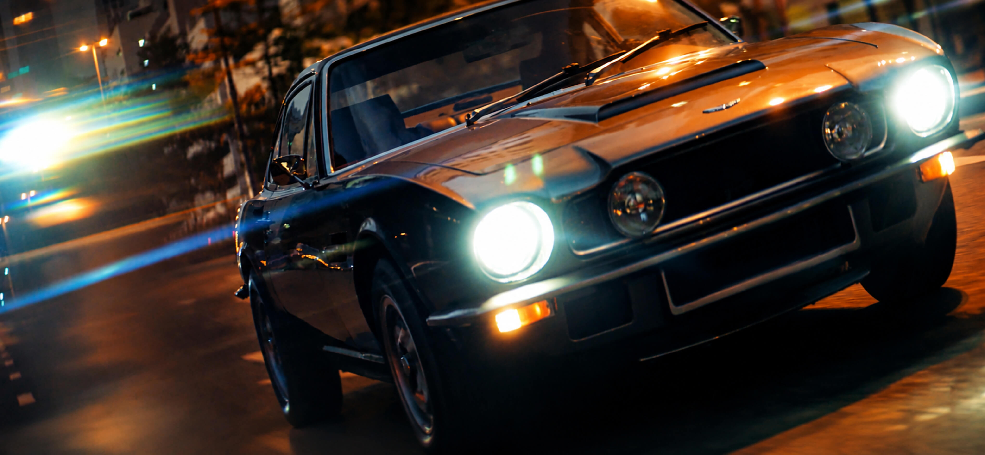 Vintage convertible driving at night with illuminated headlights in the Six Senses campaign film.