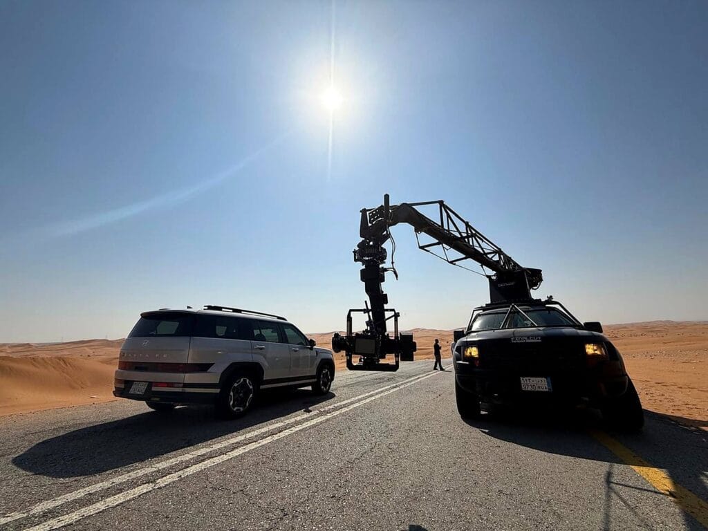 Automotive film shoot with camera crane and Hyundai SUVs on a desert road