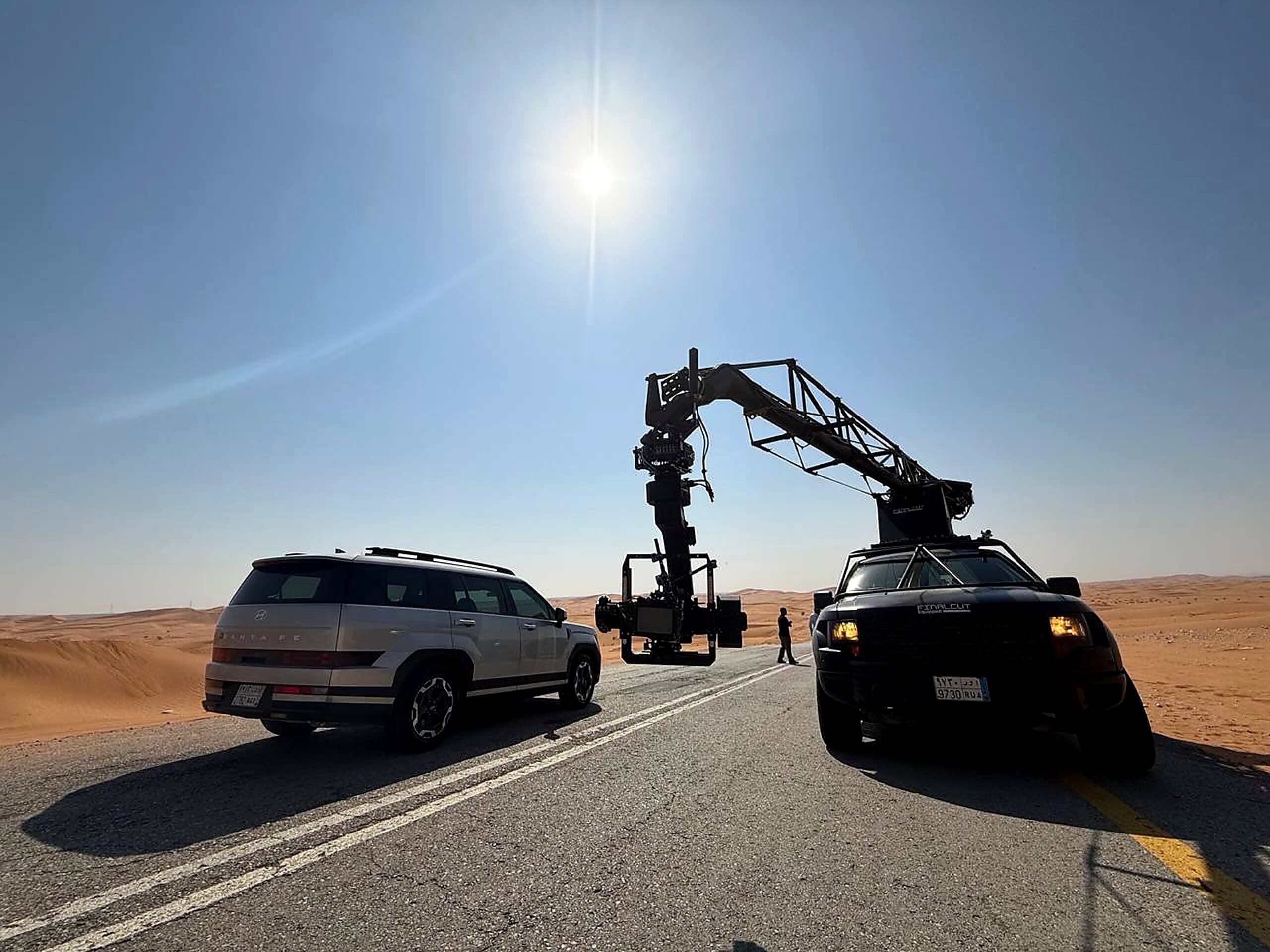 Automotive film shoot with camera crane and Hyundai SUVs on a desert road