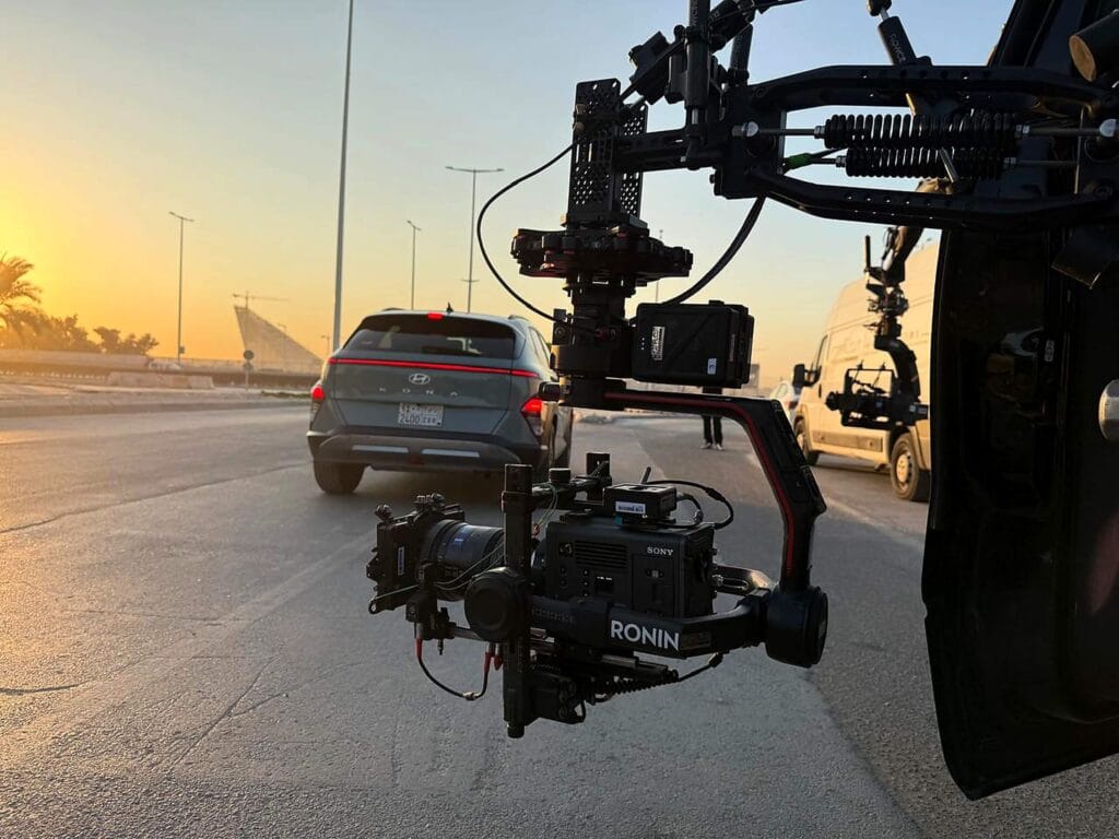 Professional automotive filming setup with Sony camera on Ronin rig at sunset