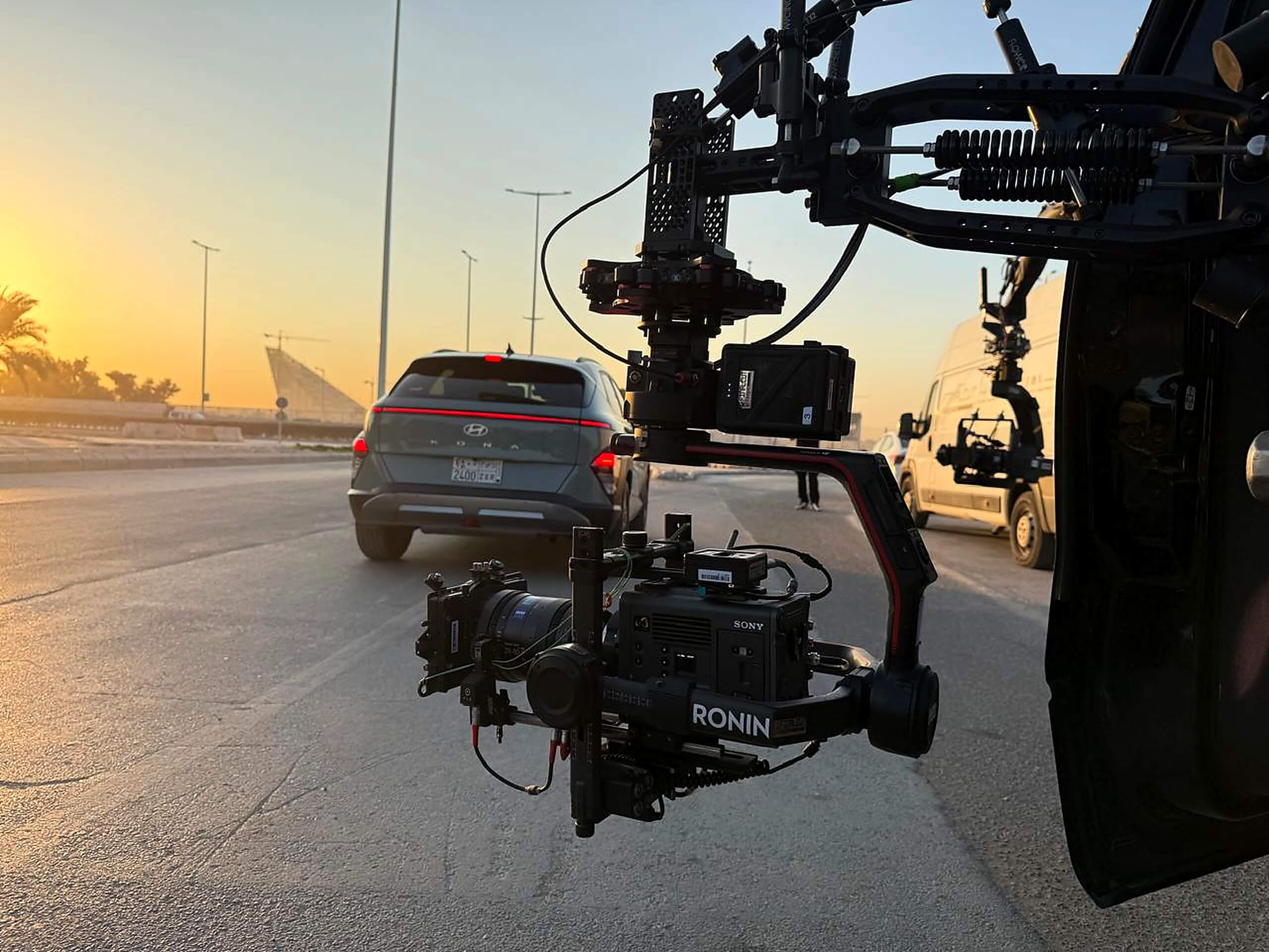 Professional automotive filming setup with Sony camera on Ronin rig at sunset