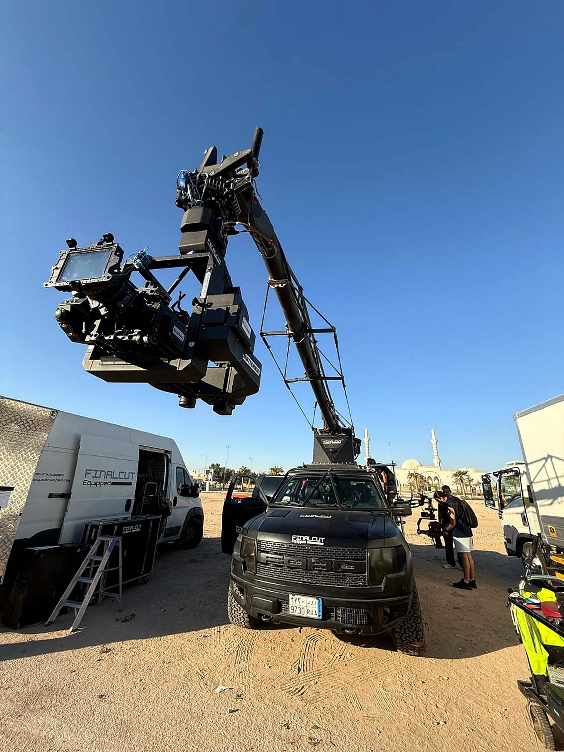 Professional camera crane mounted on a vehicle for automotive film production.