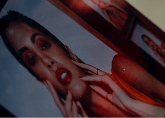Close-up portrait of a woman with red lipstick touching her face