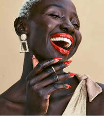 Smiling woman wearing red lipstick and bold statement earrings