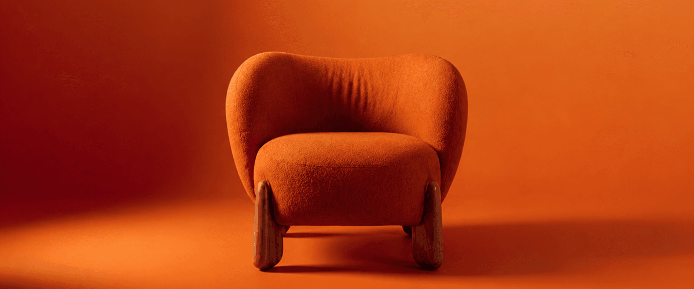 Orange sculptural armchair photographed against a warm studio background.