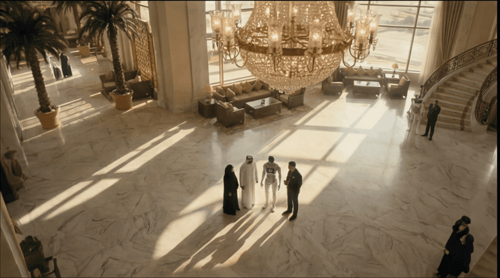 Abu Dhabi hotel lobby with people beneath a grand crystal chandelier