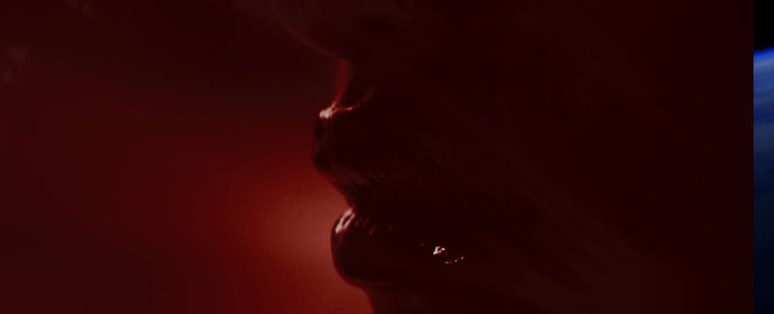 Glossy lips illuminated with deep red light in the Ayan Beauty campaign film